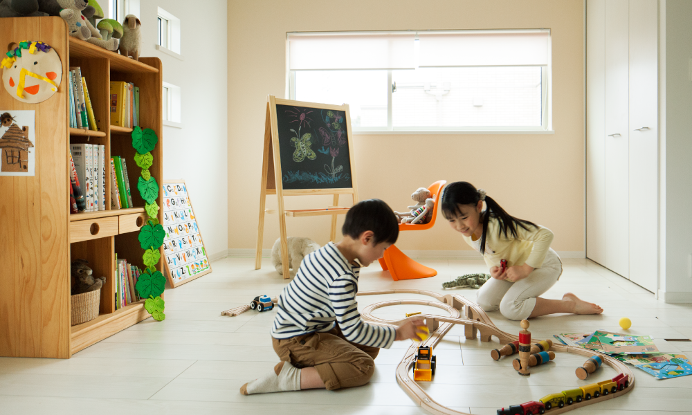 おもちゃが並ぶ室内で、子どもたちが楽しそうに遊ぶ様子の写真