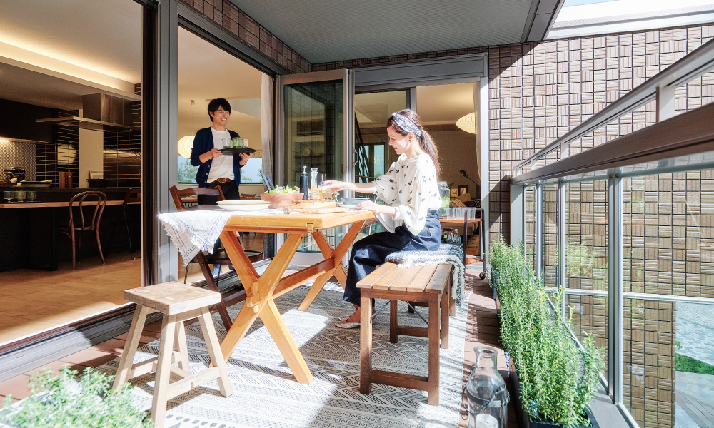 テラスで食事を楽しむ夫婦の写真