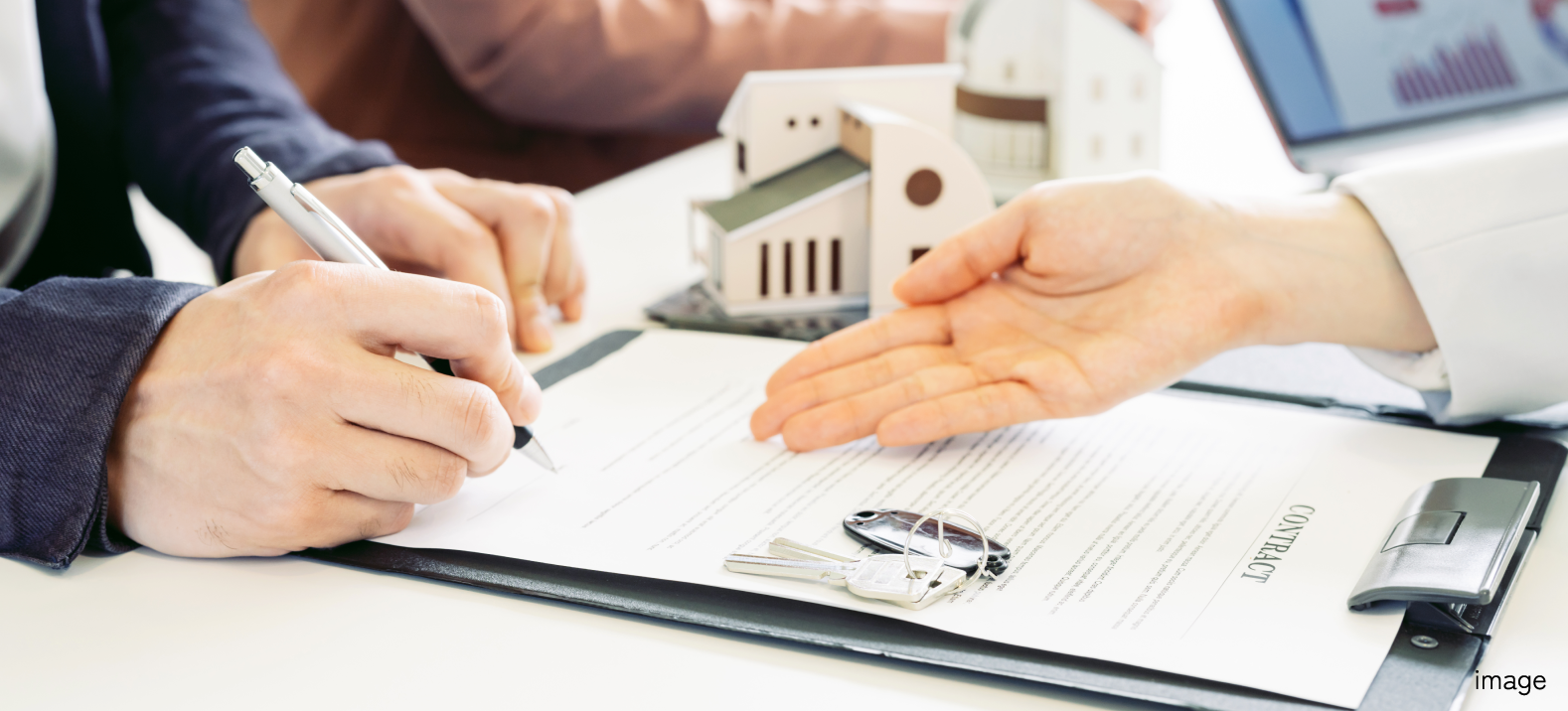 書類にサインをしている手元の写真