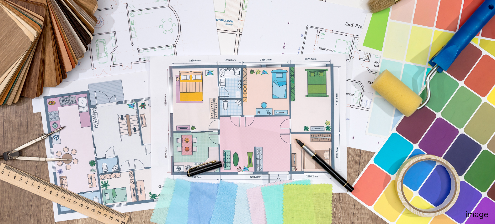 間取り図や色見本が並べられたデスクの写真
